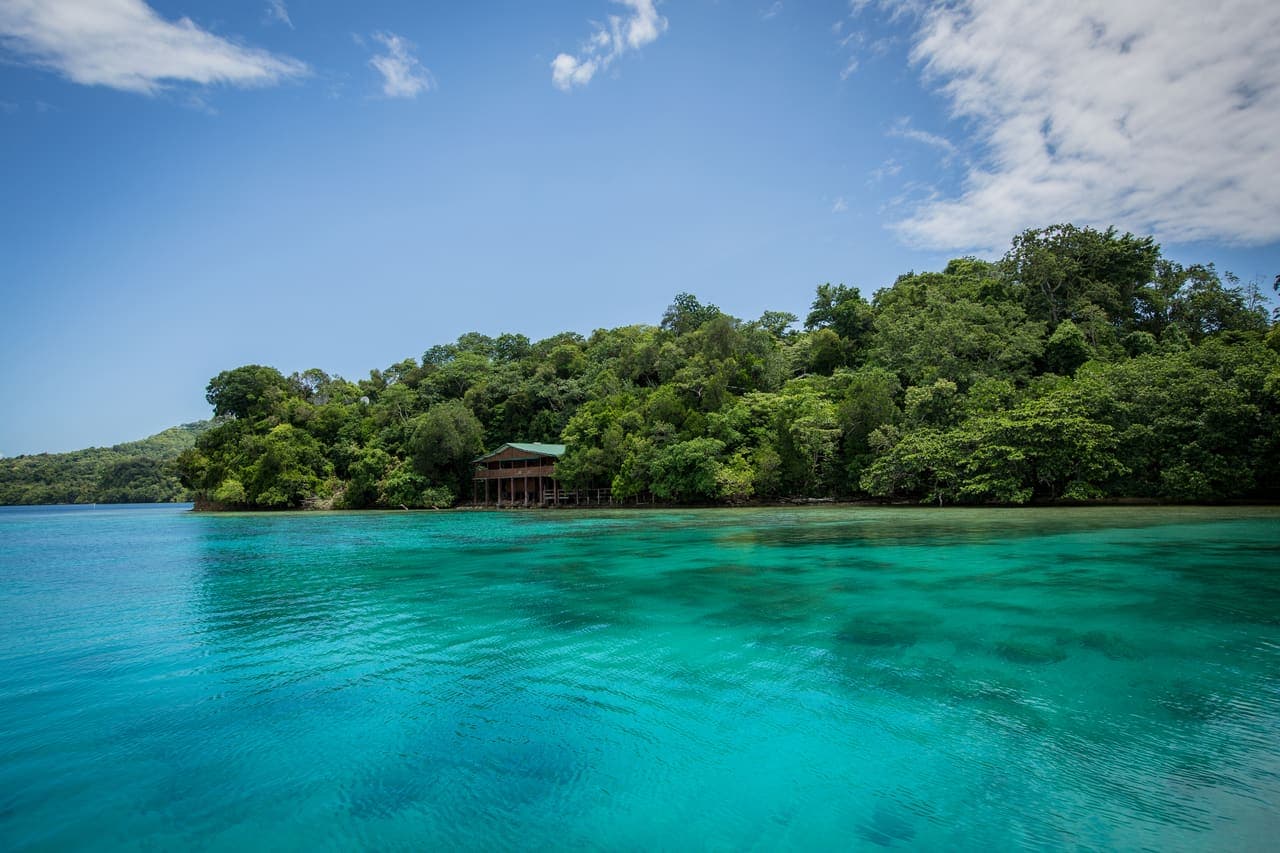 Island and turquoise lagoon near Alotau